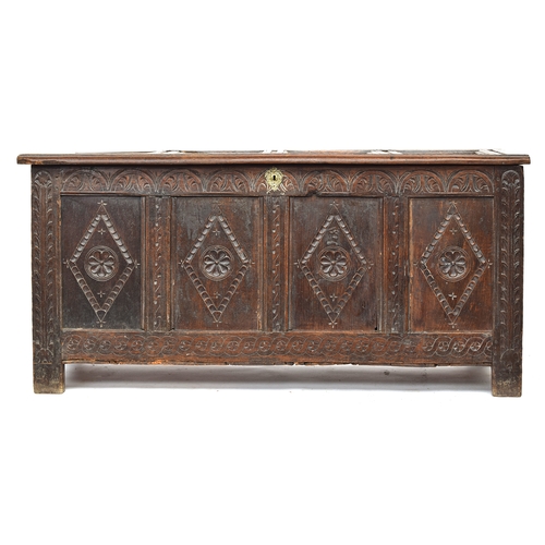 582 - A late 17th/early 18th century four panel oak coffer, demi-lune frieze over lozenge and rosette carv... 