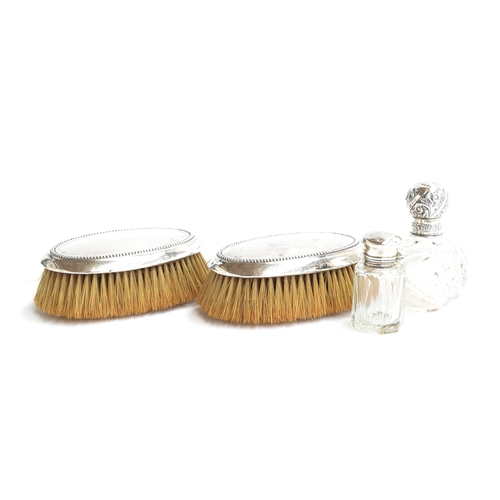 198 - A pair of silver clothes brushes by Walker & Hall, Sheffield 1902; together with two silver topped c... 