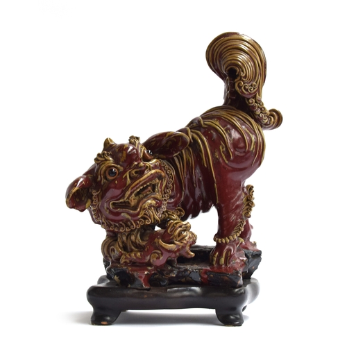 260 - A large early 20th century Chinese sang de boeuf glazed foo dog with puppy, on a carved hardwood bas... 