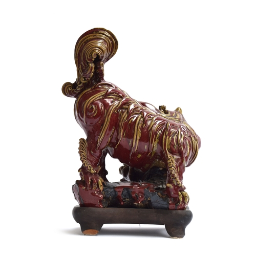 260 - A large early 20th century Chinese sang de boeuf glazed foo dog with puppy, on a carved hardwood bas... 