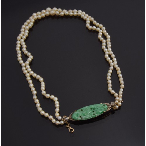 38 - A graduated two row natural pearl necklace (not tested) with carved green jade and gold fastener, th... 