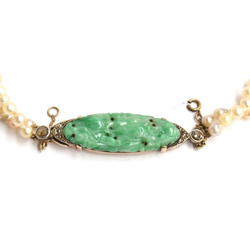 38 - A graduated two row natural pearl necklace (not tested) with carved green jade and gold fastener, th... 