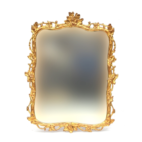 533 - A giltwood mirror, the shaped plate within a carved frame decorated with scrolling foliage, 87x110cm