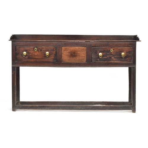 588 - An early 18th century oak sideboard, three quarter gallery over three frieze drawers, on square sect... 