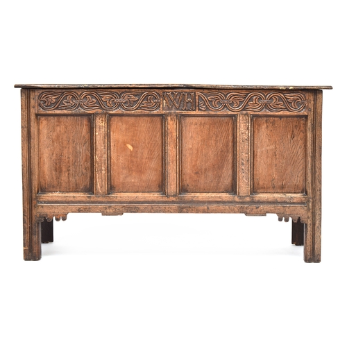 584 - An early 18th century four panel oak coffer, carved with initials WH, 134cm wide, 52cm deep, 76cm hi... 