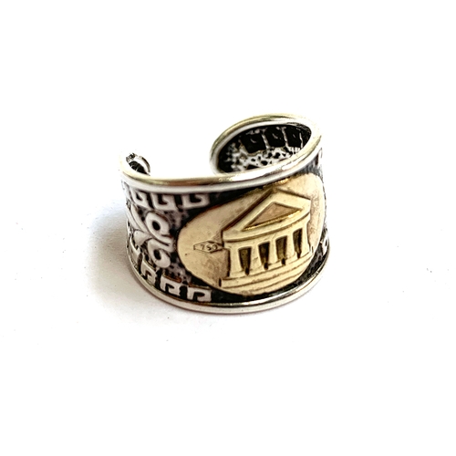 17 - An Italian 925 silver ring with embossed Greek key pattern, with an applied 18ct gold panel depictin... 