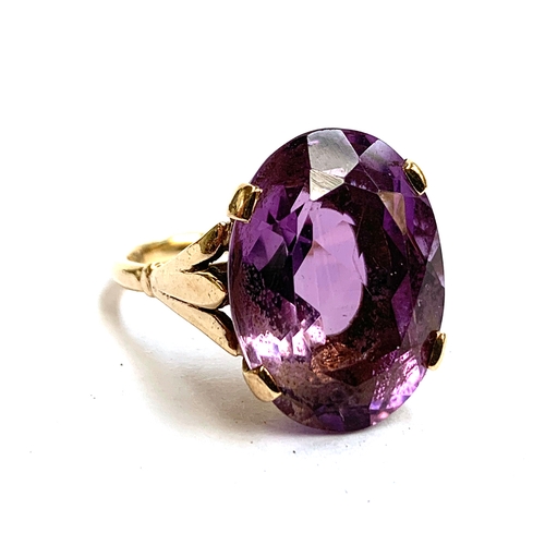 30 - A 9ct gold ring set with a large oval amethyst, the stone 2cm long, size T 1/2, 8.3g