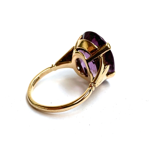 30 - A 9ct gold ring set with a large oval amethyst, the stone 2cm long, size T 1/2, 8.3g