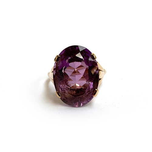 30 - A 9ct gold ring set with a large oval amethyst, the stone 2cm long, size T 1/2, 8.3g