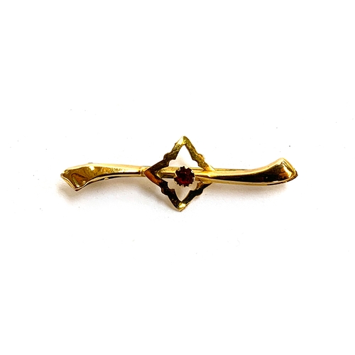 42 - A 9ct gold bar brooch set with a single red paste, 4cm long, approx. 0.9g