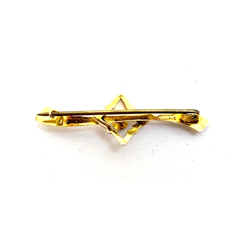 42 - A 9ct gold bar brooch set with a single red paste, 4cm long, approx. 0.9g