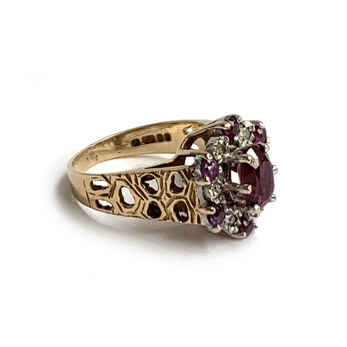 46 - A 9ct gold ring set with a central garnet surrounded by smaller garnets and illusion set diamond chi... 