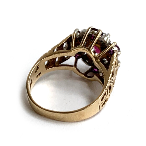 46 - A 9ct gold ring set with a central garnet surrounded by smaller garnets and illusion set diamond chi... 