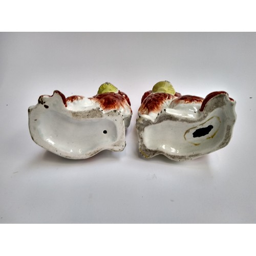 135A - A pair of 19th century Staffordshire dogs, each holding basket in mouth, 19.5cmH