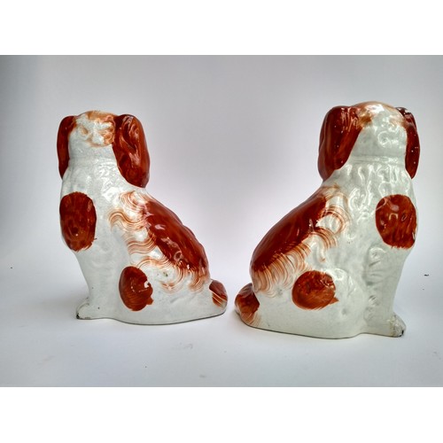 135A - A pair of 19th century Staffordshire dogs, each holding basket in mouth, 19.5cmH