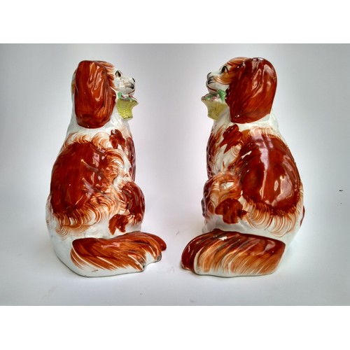 135A - A pair of 19th century Staffordshire dogs, each holding basket in mouth, 19.5cmH