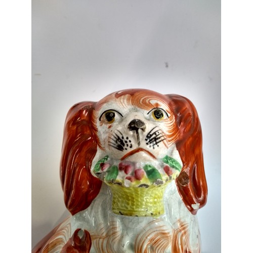 135A - A pair of 19th century Staffordshire dogs, each holding basket in mouth, 19.5cmH