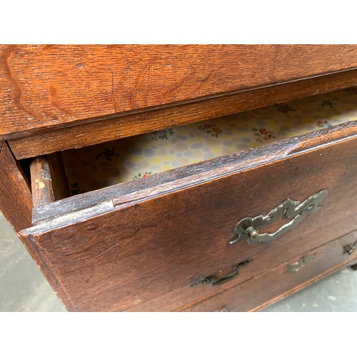 593 - A George II oak chest of drawers, the moulded top above two short and three graduating drawers with ... 