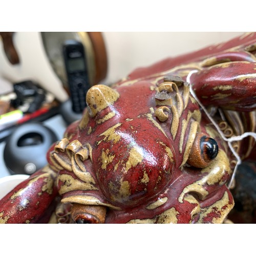 260 - A large early 20th century Chinese sang de boeuf glazed foo dog with puppy, on a carved hardwood bas... 