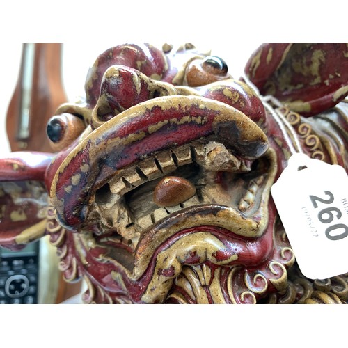 260 - A large early 20th century Chinese sang de boeuf glazed foo dog with puppy, on a carved hardwood bas... 