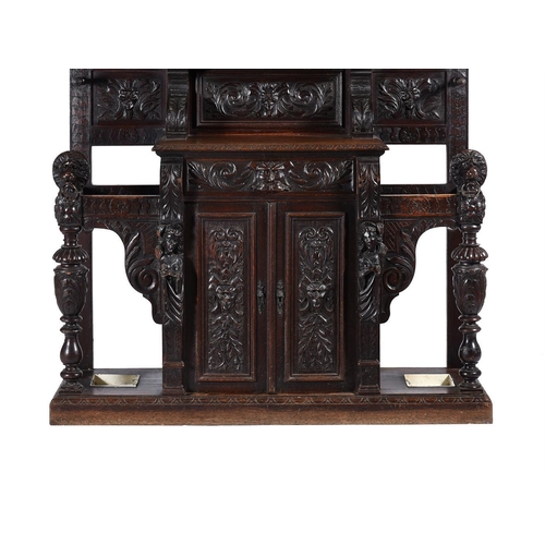 923 - A carved oak hall stand in antiquarian taste late 19th or early 20th century with ivorine label to t... 