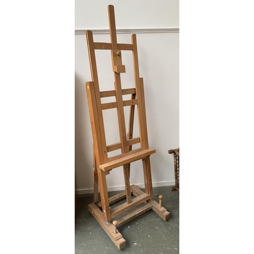 924 - A very large beechwood artists studio easel; together with a further portable easel