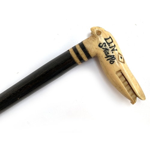 49 - An ebonised walking stick, the a carved bone handle in the form of a stylised longdog, inscribed 'CP... 