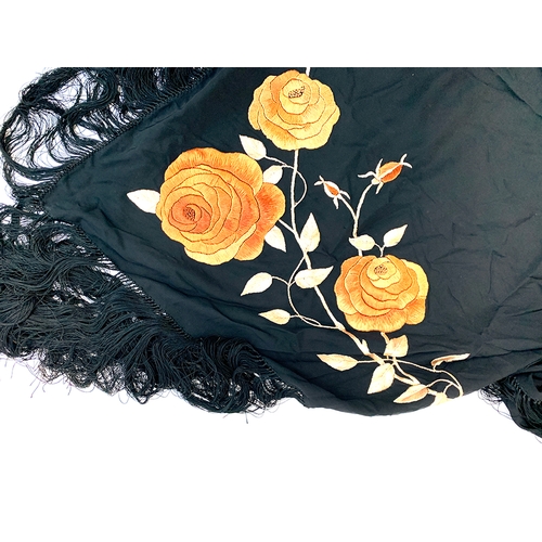 732 - An embroidered black silk fringed shawl with rose design, 100cmW