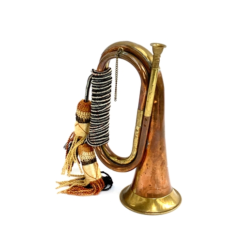 695 - A brass and copper military bugle, the dell 10.5cm diameter