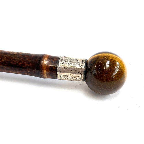 53 - A bamboo walking cane with tiger's eye knop, white metal collar monogrammed WBI, 85cm long