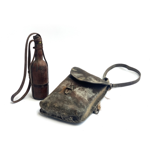 148 - An early 20th century leather food satcher, together with a glass drinking bottle in leather case wi... 