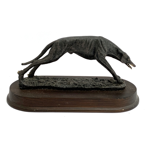 140 - A resin figure of a coursing greyhound, the plinth 32cm long