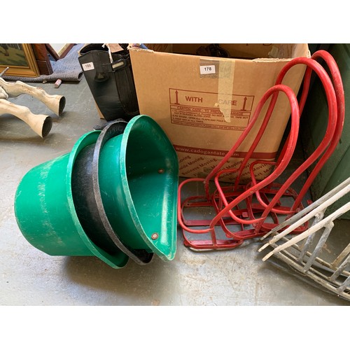 176C - Three red metal saddle racks, together with three stable door feed buckets