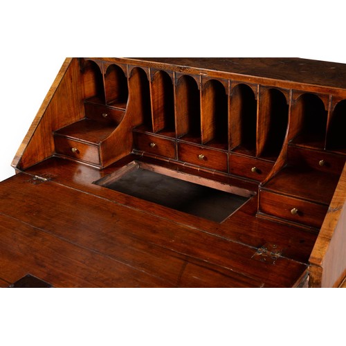 570 - An early 18th century and later walnut bureau, the fall enclosing a fitted interior with drawers and... 