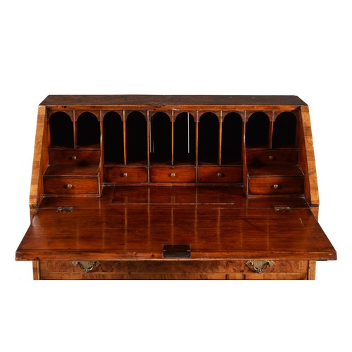 570 - An early 18th century and later walnut bureau, the fall enclosing a fitted interior with drawers and... 