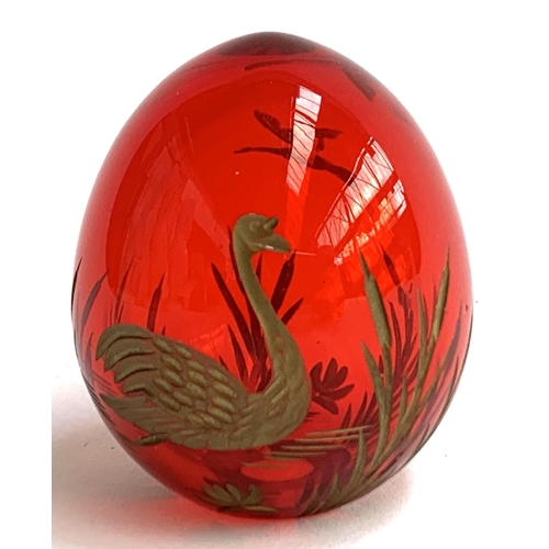 107 - A Russian Faberge style cranberry glass egg, with engraved gilt decoration of swans and rushes, 6cmH