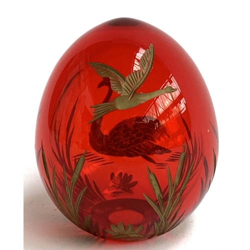 107 - A Russian Faberge style cranberry glass egg, with engraved gilt decoration of swans and rushes, 6cmH