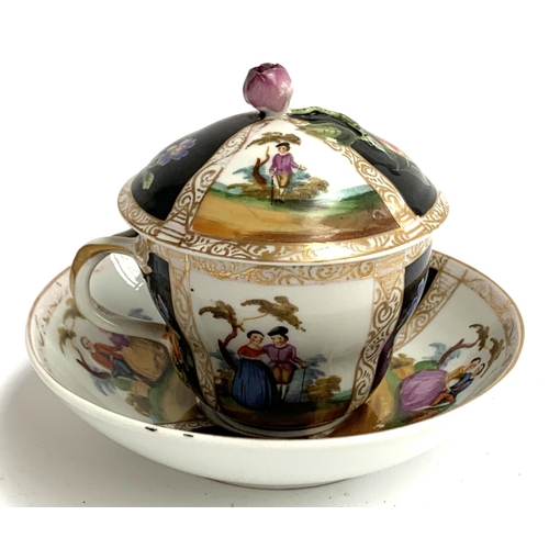 122 - A continental porcelain cup and cover with matching saucer, the cup with encrusted rose finial, the ... 