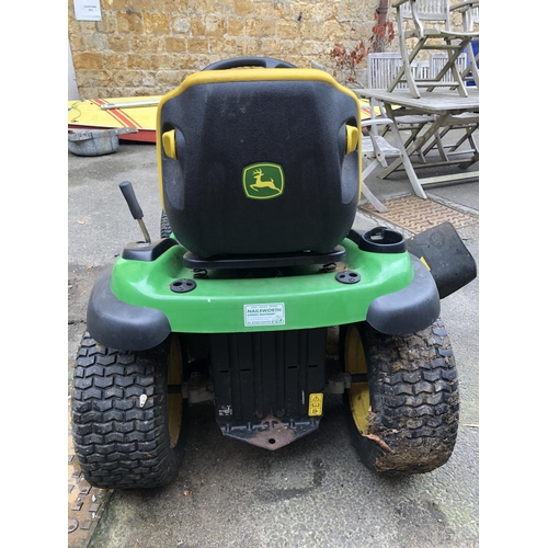 953 - A John Deere 100 series model X140 ride on lawn mower, 48 inch cutting system, with key