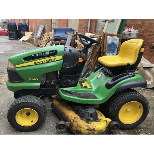 953 - A John Deere 100 series model X140 ride on lawn mower, 48 inch cutting system, with key