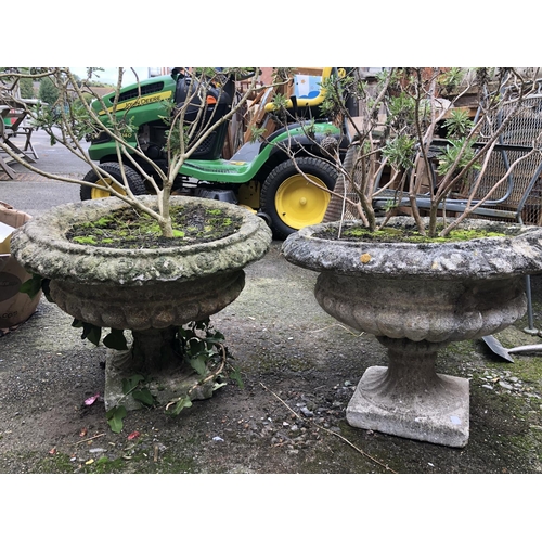 965 - A pair of composite stone garden urns on stands, 50cmD