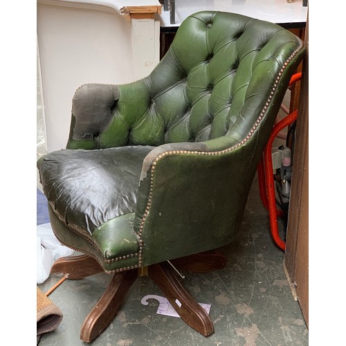 908 - A green leather button back swivel chair, with repairs