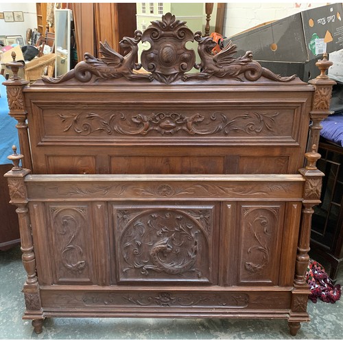 922a - A carved hardwood double bed, the headboard crested with dragons