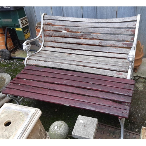 961 - A slatted garden bench with cast metal ends with lion masks, 124cmW, together with a matching table