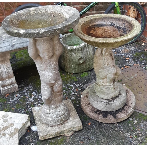 970 - Two composite stone garden birdbaths, each supported by figures, the tallest 76cmH