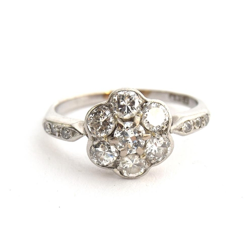 35 - An Edwardian platinum and diamond floral cluster ring, six diamonds surrounding a central diamond, t... 