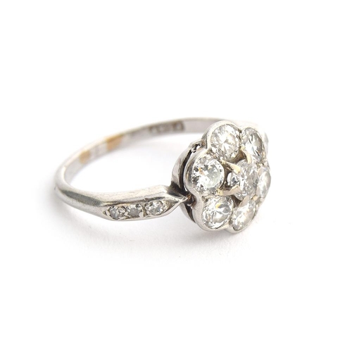 35 - An Edwardian platinum and diamond floral cluster ring, six diamonds surrounding a central diamond, t... 