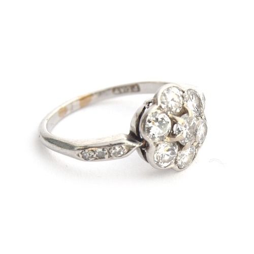 35 - An Edwardian platinum and diamond floral cluster ring, six diamonds surrounding a central diamond, t... 