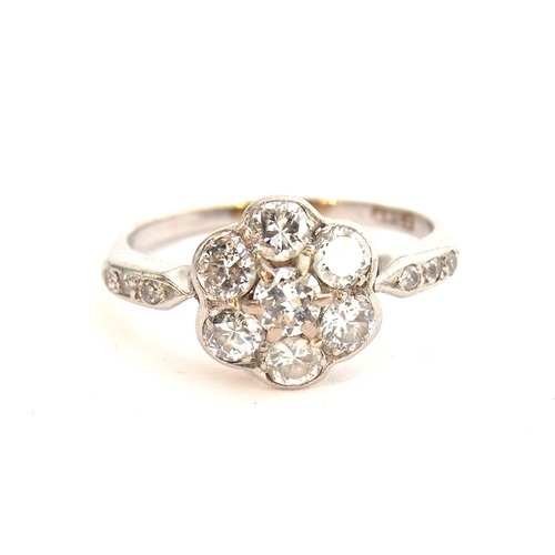 35 - An Edwardian platinum and diamond floral cluster ring, six diamonds surrounding a central diamond, t... 