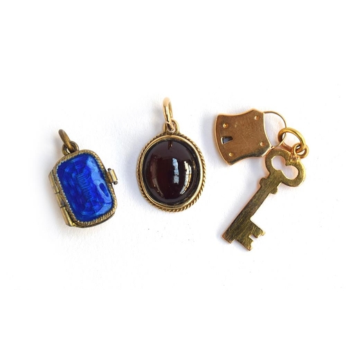 26 - A 14ct gold pendant set with a garnet cabochon, 1.4cm long; together with a yellow metal padlock and... 